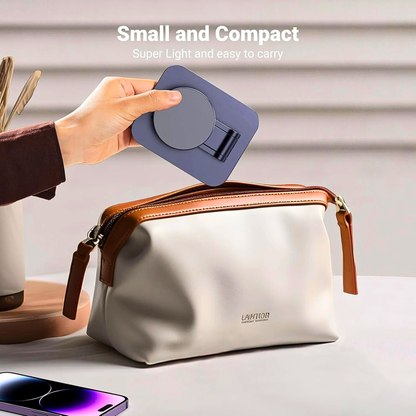 Hand holding a small blue device above a beige toiletry bag with 'LAMITON' branding.